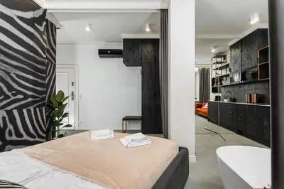 a bedroom with a bed and a tub in a room at Apartamenty Jubilat - KRK FOR STAY in Kraków