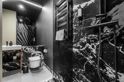 a black and white bathroom with a toilet and a sink at Apartamenty Jubilat - KRK FOR STAY in Kraków