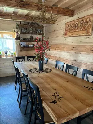 a wooden table with chairs and a vase with flowers on it at Oskarówka domek w górach na odludziu z jacuzzi i sauną - kominek i Netflix in Szczawa