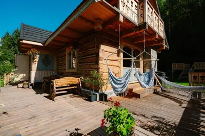 a house with a hammock on a wooden deck at Oskarówka domek w górach na odludziu z jacuzzi i sauną - kominek i Netflix in Szczawa