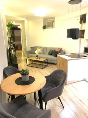 a living room with a table and chairs and a couch at Moderno Apartament in Kraków
