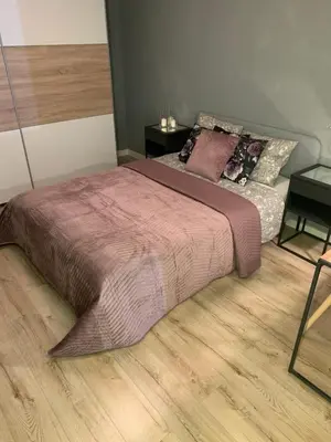 a bedroom with a large bed and a wooden floor at Moderno Apartament in Kraków