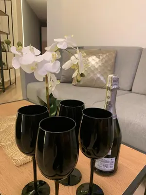a table with three wine glasses and a bottle at Moderno Apartament in Kraków