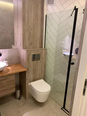 a bathroom with a toilet and a sink and a shower at Moderno Apartament in Kraków