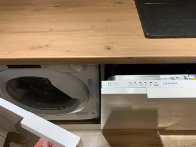 a microwave under a counter with a person reaching for it at Moderno Apartament in Kraków