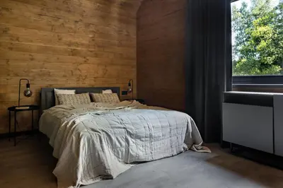 a bedroom with a bed with a wooden wall at Chillout Ślemień nowoczesny dom w górach in Ślemień