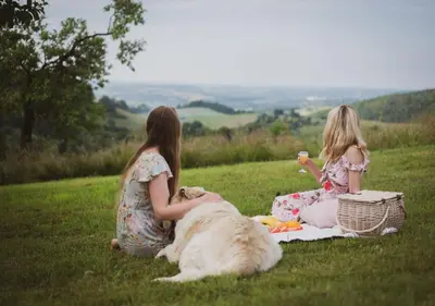 two girls sitting on a field with a dog at Bliżej Nieba in Skrzydlna