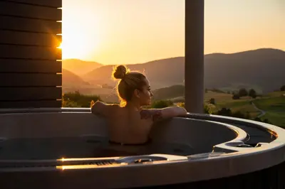 a woman in a bathtub with the sunset in the background at Bliżej Nieba in Skrzydlna