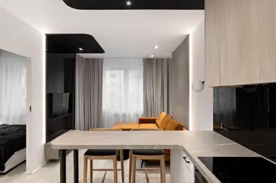 a kitchen and living room with a table and chairs at Republiki Korczakowskiej Apartamenty in Kraków