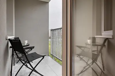 a room with a balcony with chairs and a table at Republiki Korczakowskiej Apartamenty in Kraków
