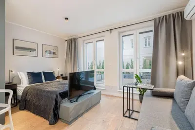 a bedroom with a bed and a tv and a couch at Czarnowiejska 21A by Homeprime in Kraków