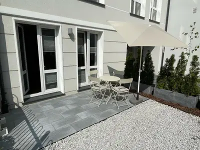 a patio with a table and chairs and an umbrella at Czarnowiejska 21A by Homeprime in Kraków