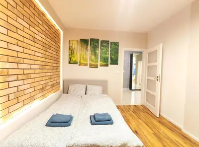 a bedroom with a bed with two blue pillows on it at Szafrana 5B by Homeprime in Kraków