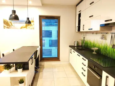 a kitchen with white cabinets and black countertops at Szafrana 5B by Homeprime in Kraków