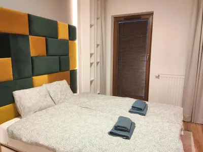 a bedroom with a bed with two slippers on it at Szafrana 5B by Homeprime in Kraków
