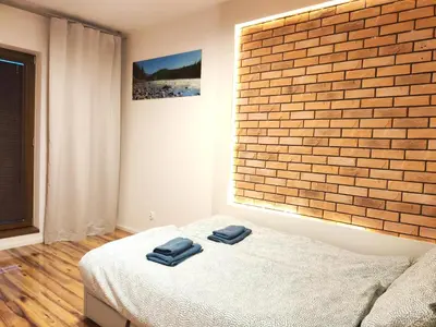 a bedroom with a bed and a brick wall at Szafrana 5B by Homeprime in Kraków