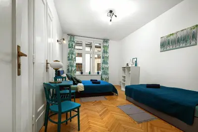 a bedroom with two beds and a table and a chair at Apartament blisko Wawelu in Kraków