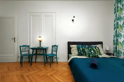 a bedroom with a bed and two chairs and a table at Apartament blisko Wawelu in Kraków