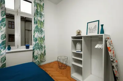 a bedroom with a bed and a shelf and a window at Apartament blisko Wawelu in Kraków