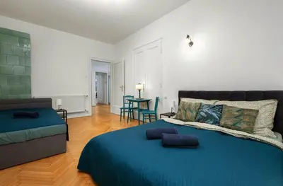 a bedroom with a blue bed and a couch at Apartament blisko Wawelu in Kraków