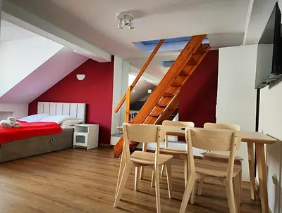a room with a table and chairs and a bed at Apartament Winnica in Kraków