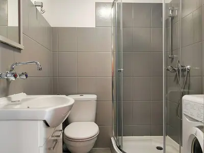 a bathroom with a toilet and a sink and a shower at Apartament Winnica in Kraków