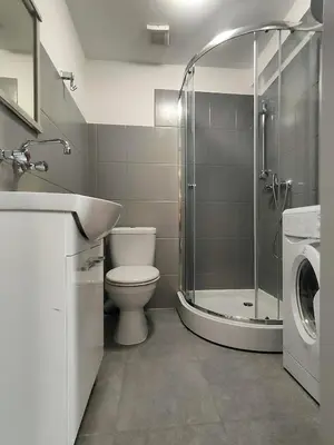 a bathroom with a toilet and a shower and a sink at Apartament Winnica in Kraków