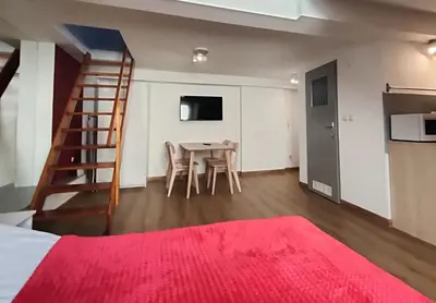 a bedroom with a bed and a table with chairs at Apartament Winnica in Kraków