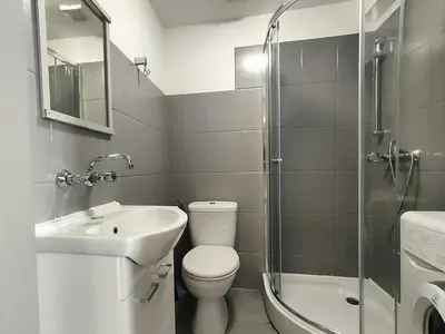 a bathroom with a toilet and a sink and a shower at Apartament Winnica in Kraków
