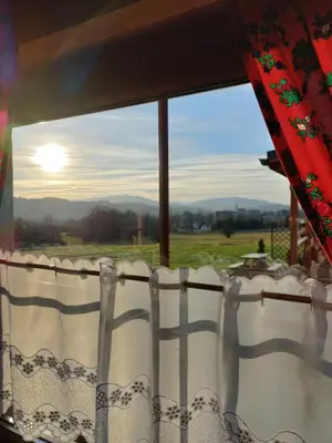 a window with a view of a field and the sun at POD STARĄ PODKOWĄ komfortowy domek z kominkiem in Limanowa