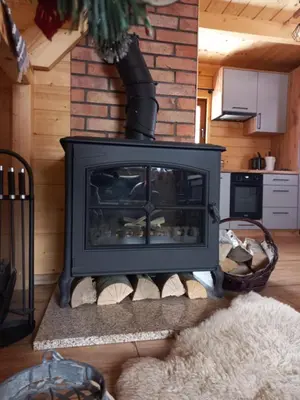 a black fireplace in a living room with at POD STARĄ PODKOWĄ komfortowy domek z kominkiem in Limanowa