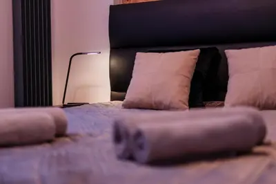 a bedroom with a bed with a black headboard and white pillows at Luna Prestige Suite - Old Town Center & Main Station in Kraków