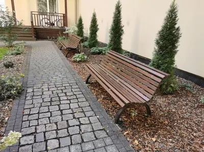 a bench sitting in a garden with a brick walkway at CHILLOUT APARTMENT SAREGO in Kraków