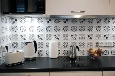 a kitchen with a black counter top with a counter top at CHILLOUT APARTMENT SAREGO in Kraków