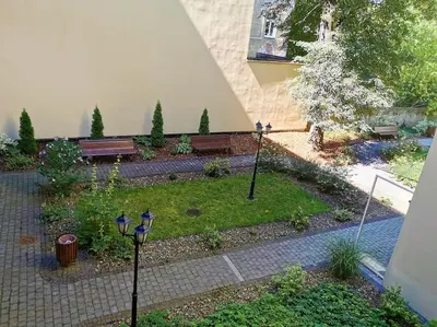 a garden with two lights and a bench at CHILLOUT APARTMENT SAREGO in Kraków