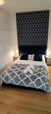 a bedroom with a bed with a blue and white comforter at CHILLOUT APARTMENT SAREGO in Kraków