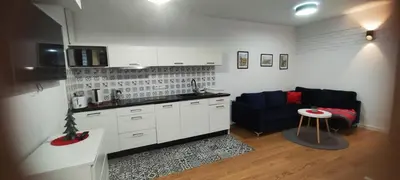 a kitchen with white cabinets and a black couch at CHILLOUT APARTMENT SAREGO in Kraków