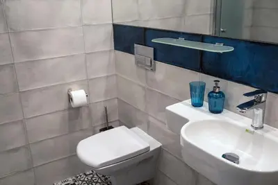 a bathroom with a sink and a toilet and a mirror at CHILLOUT APARTMENT SAREGO in Kraków