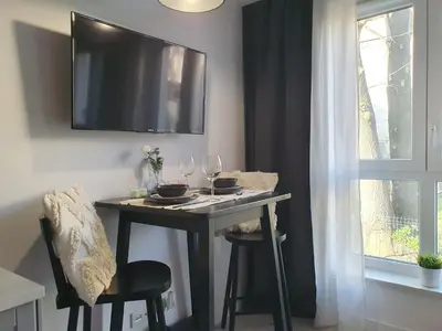 a table with wine glasses and a tv on a wall at Fly_to_Cracow_14 in Kraków