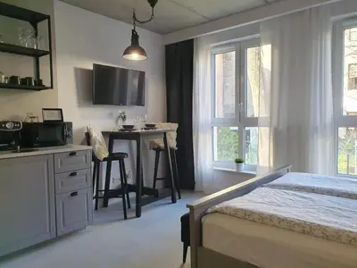 a bedroom with a bed and a desk and a table at Fly_to_Cracow_14 in Kraków