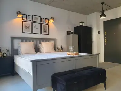 a bedroom with a large bed with a blue ottoman at Fly_to_Cracow_14 in Kraków