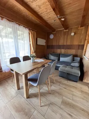a living room with a table and a couch at Domki- Limanowa, domki z balią i sauną in Limanowa