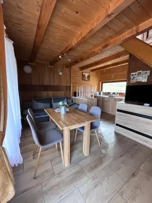 a dining room with a wooden table and chairs at Domki- Limanowa, domki z balią i sauną in Limanowa