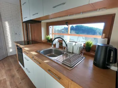 a kitchen counter with a sink and a window at Domek na Folwarku z jacuzzi in Tarnawa Dolna