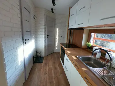 a kitchen with white cabinets and a sink at Domek na Folwarku z jacuzzi in Tarnawa Dolna