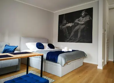 a bedroom with a bed with a painting on the wall at Hugo VIP Apartments in Kraków