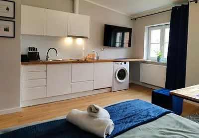 a kitchen with white cabinets and a washing machine at Hugo VIP Apartments in Kraków