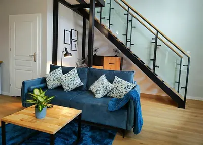 a living room with a blue couch and a table at Hugo VIP Apartments in Kraków