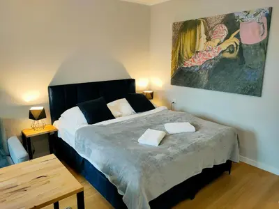 a bedroom with a large bed with two towels on it at Hugo VIP Apartments in Kraków