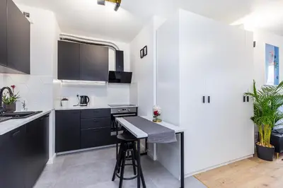 a kitchen with black and white cabinets and a counter at Cloud9 - Barska 69 in Kraków